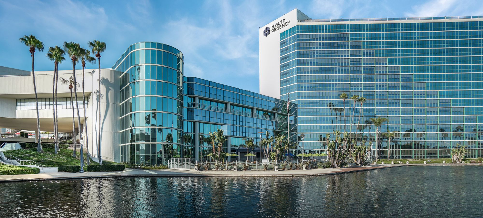 Hyatt Regency waterfront at Long Beach, glass façade and palms under a blue sky